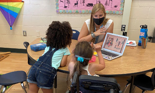 COEHS Student Colleen uses sign language with 2 students