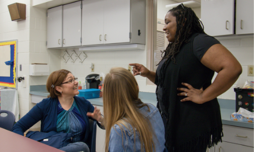 Tia giving instruction to two teachers in TESOL classroom at Kings Trail