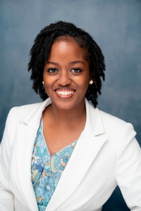 Woman smiling in front of gray backdrop