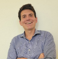 Headshot of Blake Rayfield smiling with a light faded yellow background