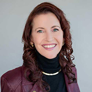 Headshot of June Cotte, smiling with a gray background.