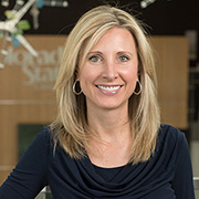 Headshot of kelly martin in a blurred background with office setup