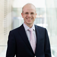 Headshot of Sebastian Fourne, smiling with a blurred background in a building indoor  