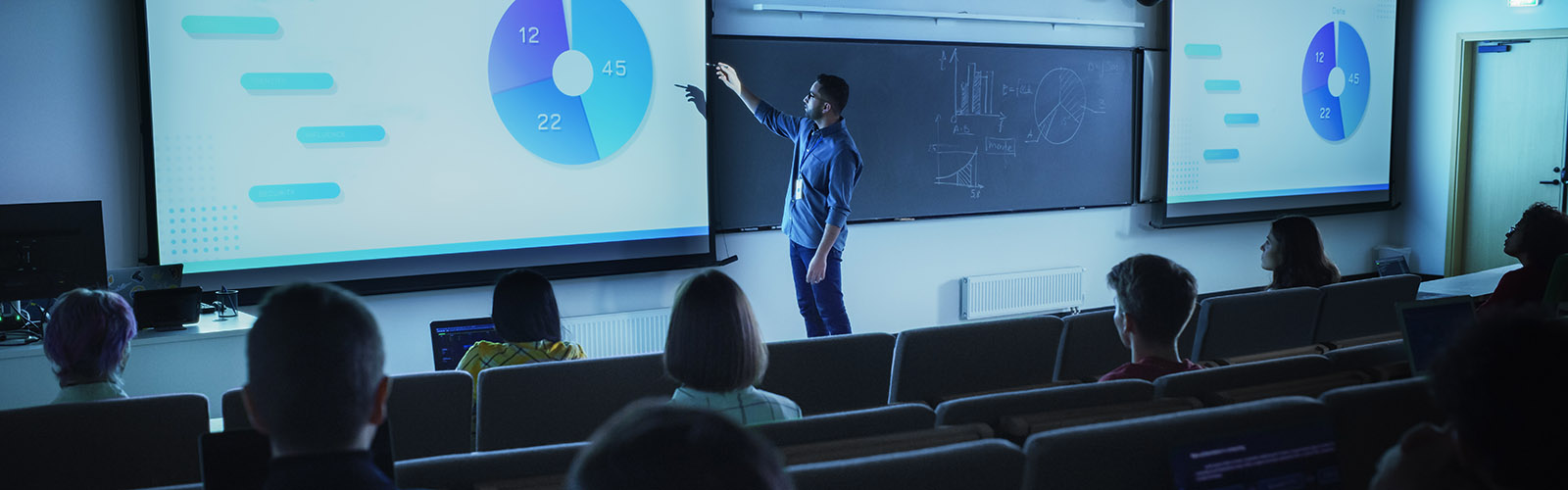 instructor talking about a pie chart in front of a classroom of students