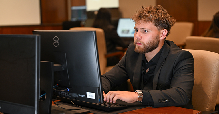 business student working on a computer
