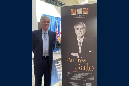 Dr. Gallo standing next to a sign with an image of him and the names Andres Gallo