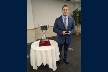 Osprey Financial Group winner holding an award next to a trophy