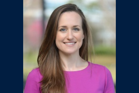 Headshot of Rachel Frieder with a pink shirt and a blurred green background