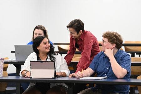 UNF professor and three students gathered around a tablet 