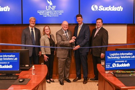 Suddath Lab Opening with four people holding a scissor and cutting a ribbon