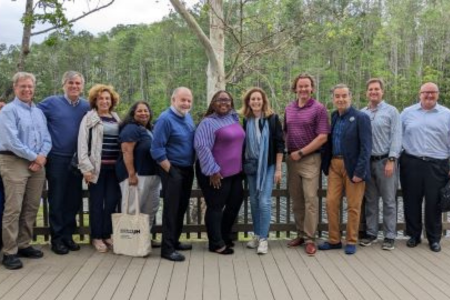 Group of people smiling in front of a lake