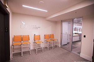 UNF office lobby with 5 orange chairs and glass entrance door