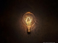 A photo of a light bulb with a brown background of gears
