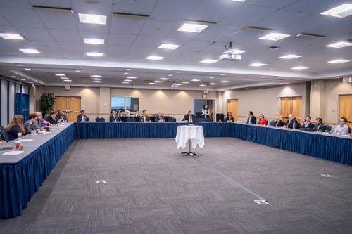 Group of people sitting at a blue table and a table in the middle