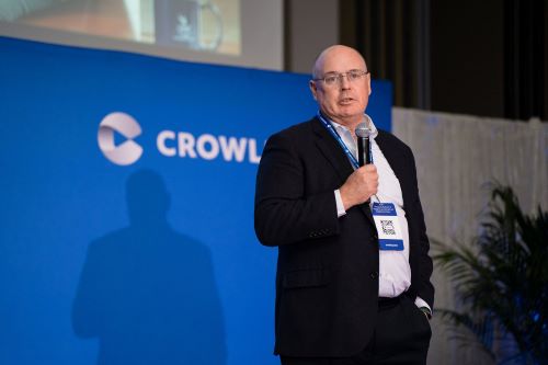 Dean Buttimer speaking and holding a microphone at a Crowley event