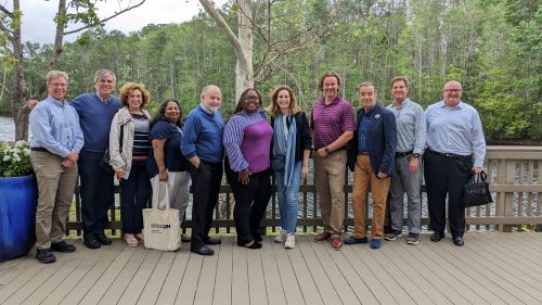 Group of people smiling in front of a lake