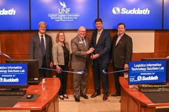 Suddath Lab Opening with four people holding a scissor and cutting a ribbon 