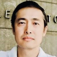 headshot of Di shang outdoor with a wall as background