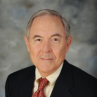 Headshot of Earle Traynham wearing a suit with a red tie