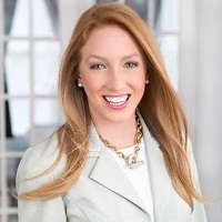 A headshot of Julie O'Meara wearing a necklace and gray blazer