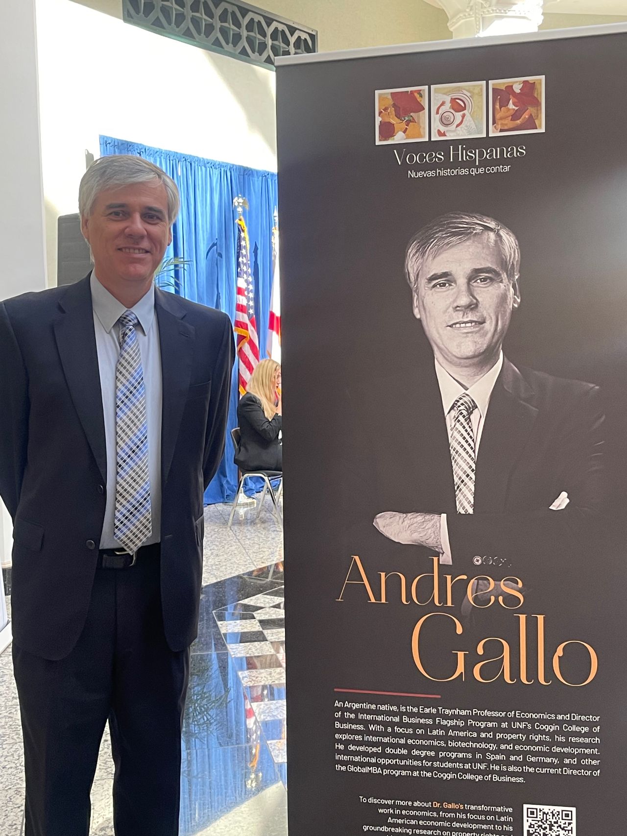 Dr. Gallo standing next to a sign with an image of Dr. Gallo and his name Andres Gallo