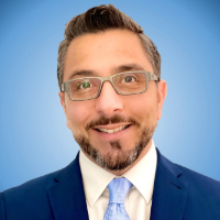 Headshot of Pablo Diaz-de-Sandi with a sky blue background, which is fading white to the center of the images.