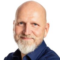 Headshot of carsten demuth wearing a blue shirt with a white background