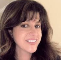 Headshot of Maria Isabel Montoya with beige background and bangs