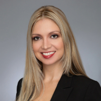 Headshot of Monica Hernandez with a gray background.