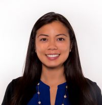 Headshot of Tami wearing a blue shirt with a necklace and white background