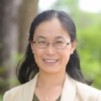 Headshot of Pingying Zhang wearing glasses, earrings and beige blazer