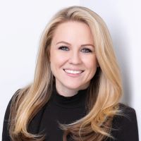 Headshot of Jackie Gonsalez wearing black turtleneck with white background