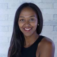 Headshot of Kimberly Frye Alula with black shirt and white brick background