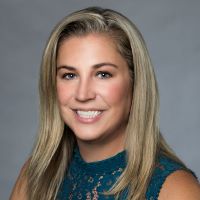 Headshot of Sara Leutzinger Pomposo wearing green shirt with gray background