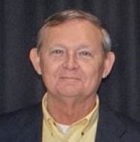 Headshot of Ronald Daams wearing black blazer with yellow shirt with black background