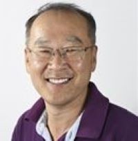 Headshot of Young Tae Choi wearing blazer with white background glasses and a magenta