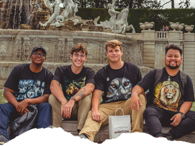 four student sitting at a fountain in Czech Republic