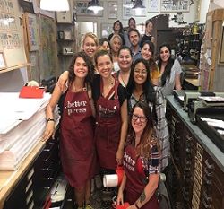 group of students smiling while wearing aprons