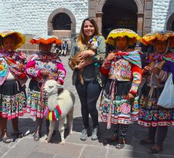 student holding a goat next to some people