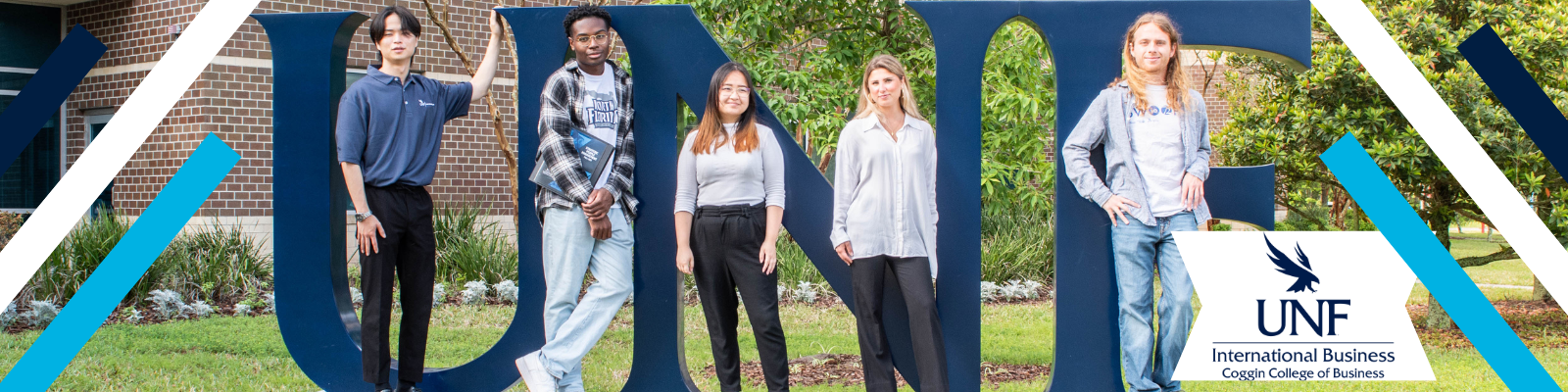 5 international business students standing next to a blue metal UNF sign with international business logo in blue in the bottom right corner 