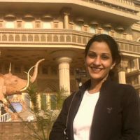 Dr. Kaushal in front of a building and a statue of an elephant