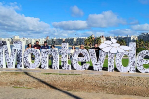 monument spelling Montevideo along the beach with UNF students