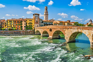 concrete bridge across river with buildings in the background