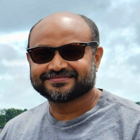 close-up of Dr. Chatterjee with sunglasses and a blue sky background
