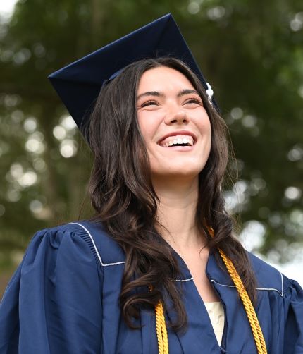A female student wears a gold honors cord. 