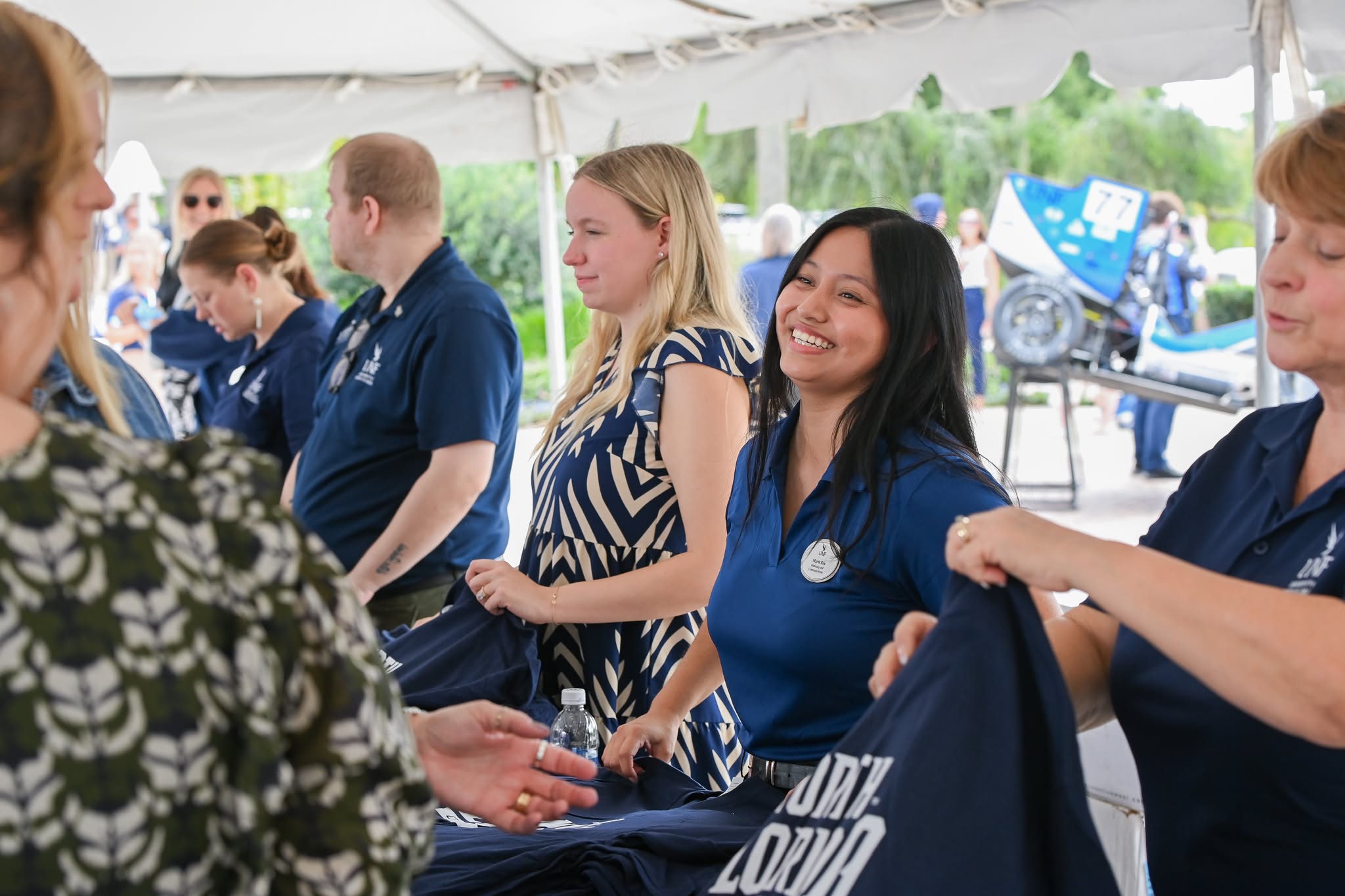 Staff passing out t-shirts at Convocation