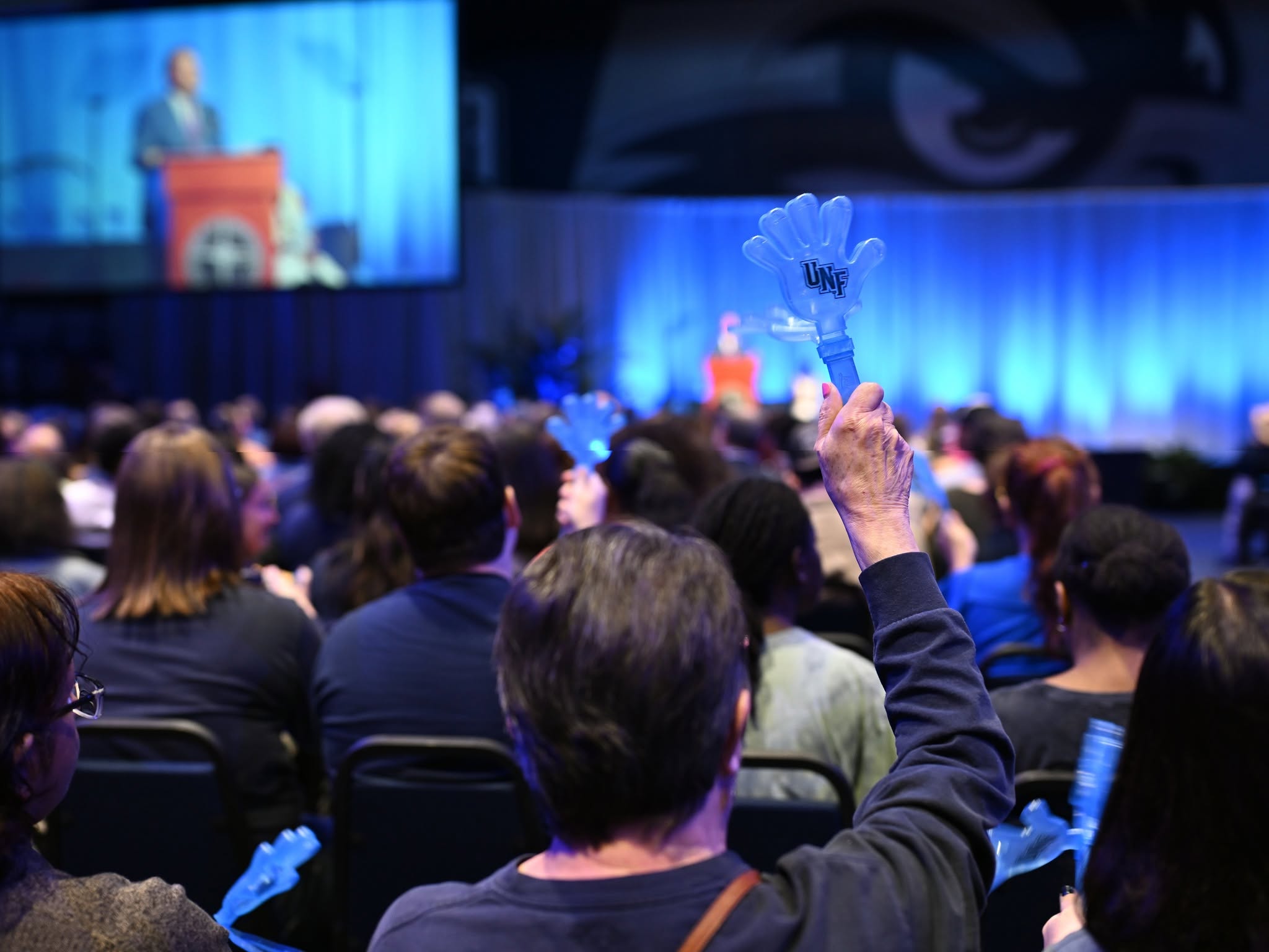 Audience member waving a clappy hand