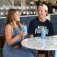 two students enjoying a beverage