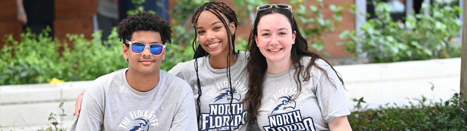 three students sitting outside the student union