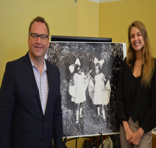 Two individuals stand in front of black and white poster